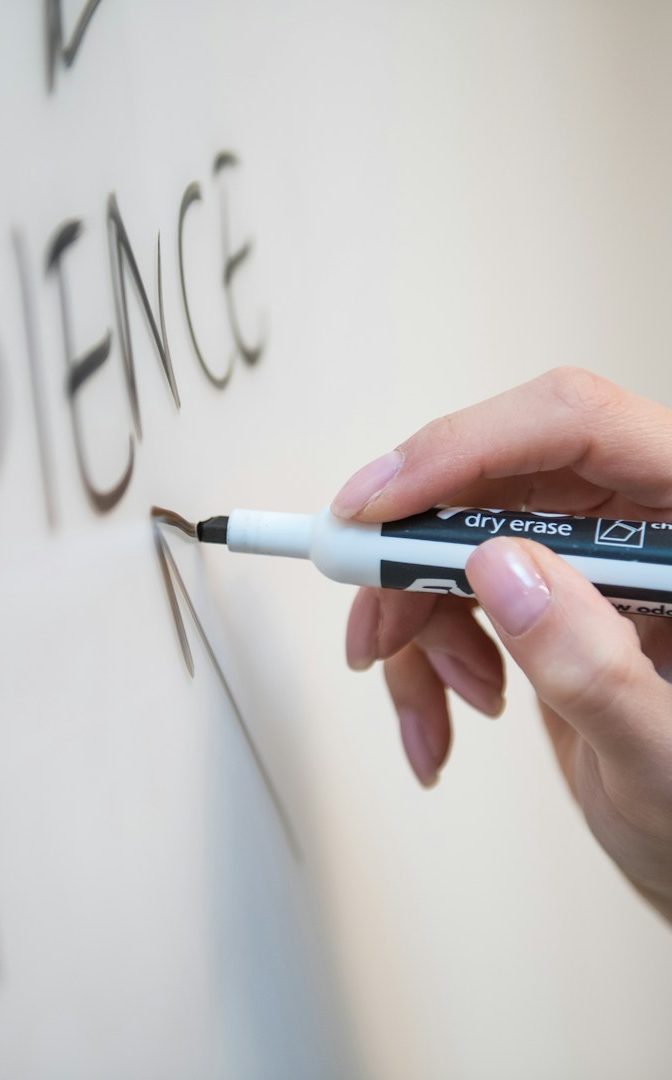 Hand beim Schreiben auf einem Whiteboard